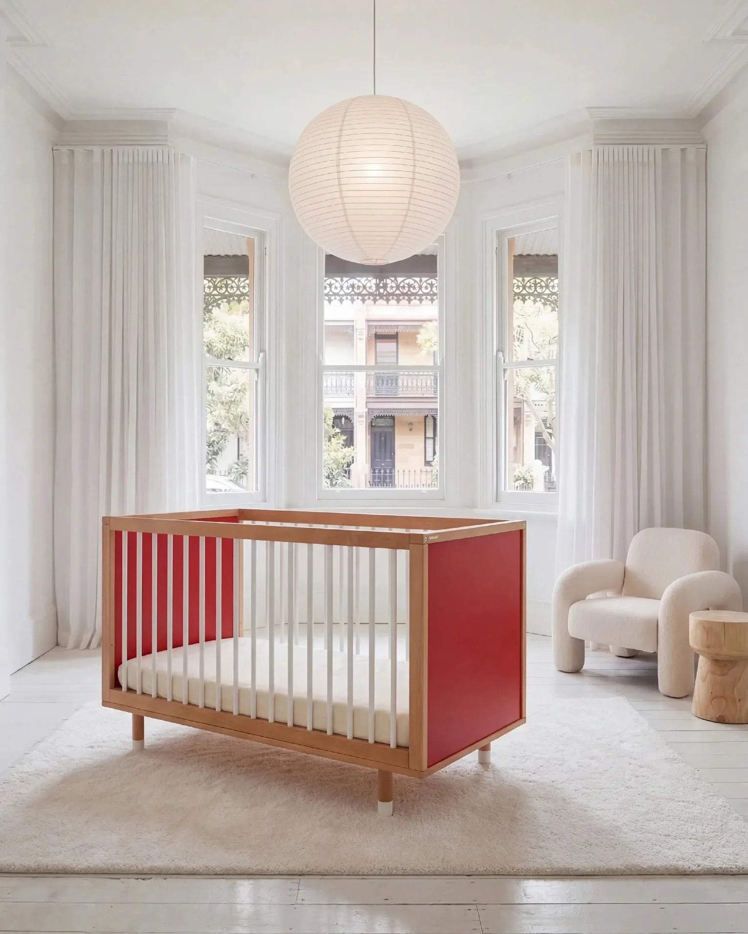 Bold Baby Cot in Pink and Red colourway, front three-quarter view showing the red panel