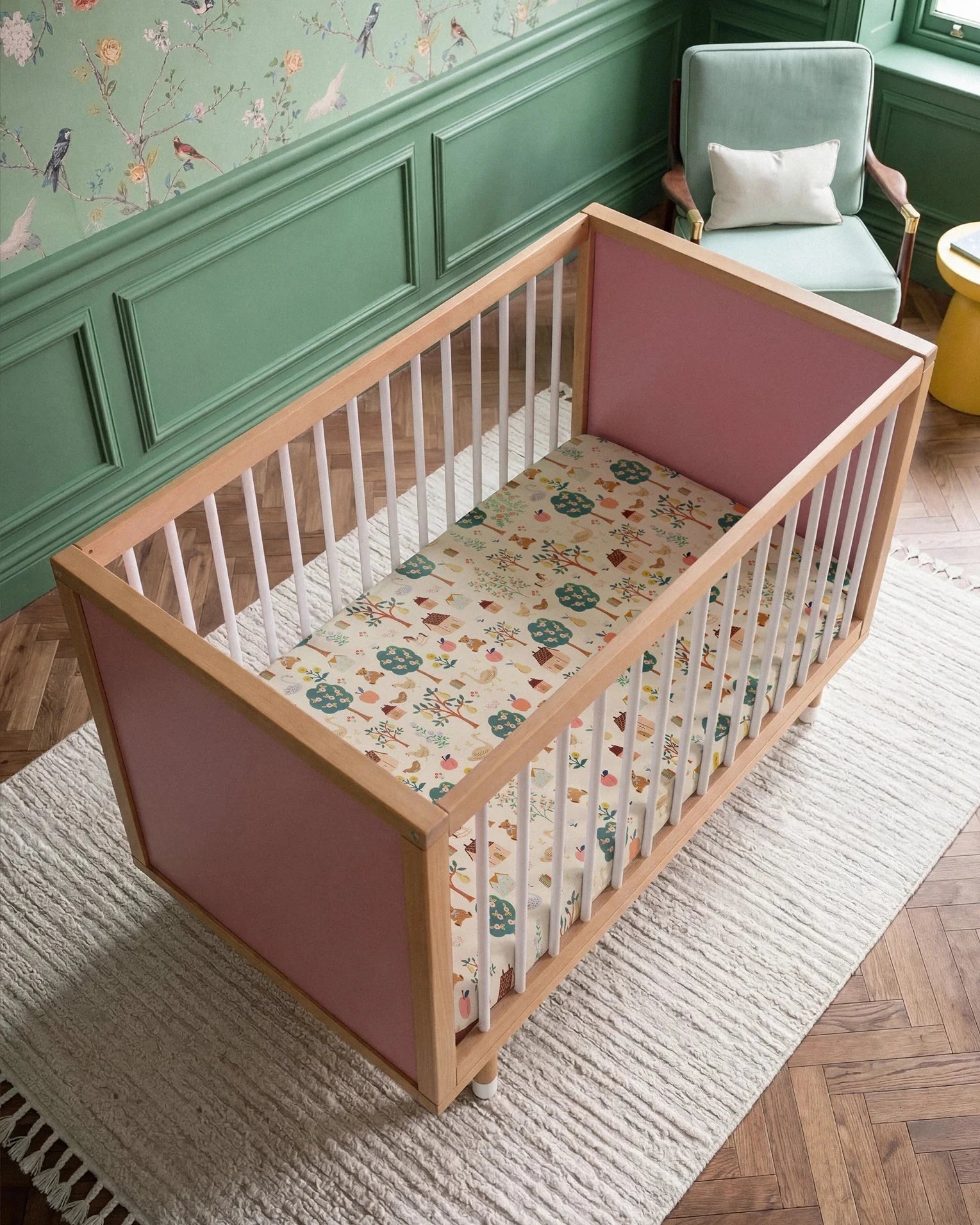 Overhead view of the Pink and Green Bold Baby Cot. Pink panels on display.