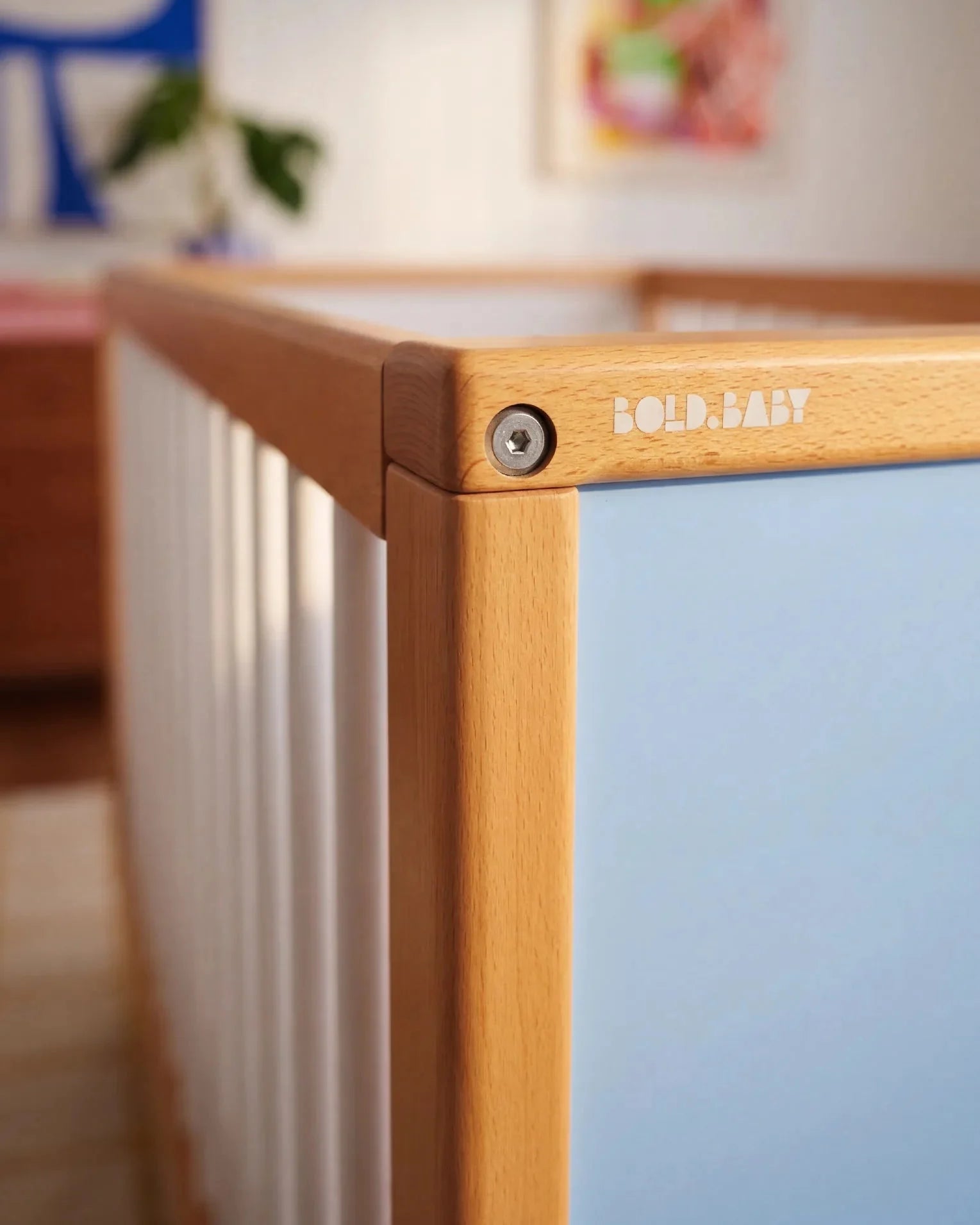 Close-up corner detail of the interchangeable panel on the Blue and Deep Blue Bold Baby Cot
