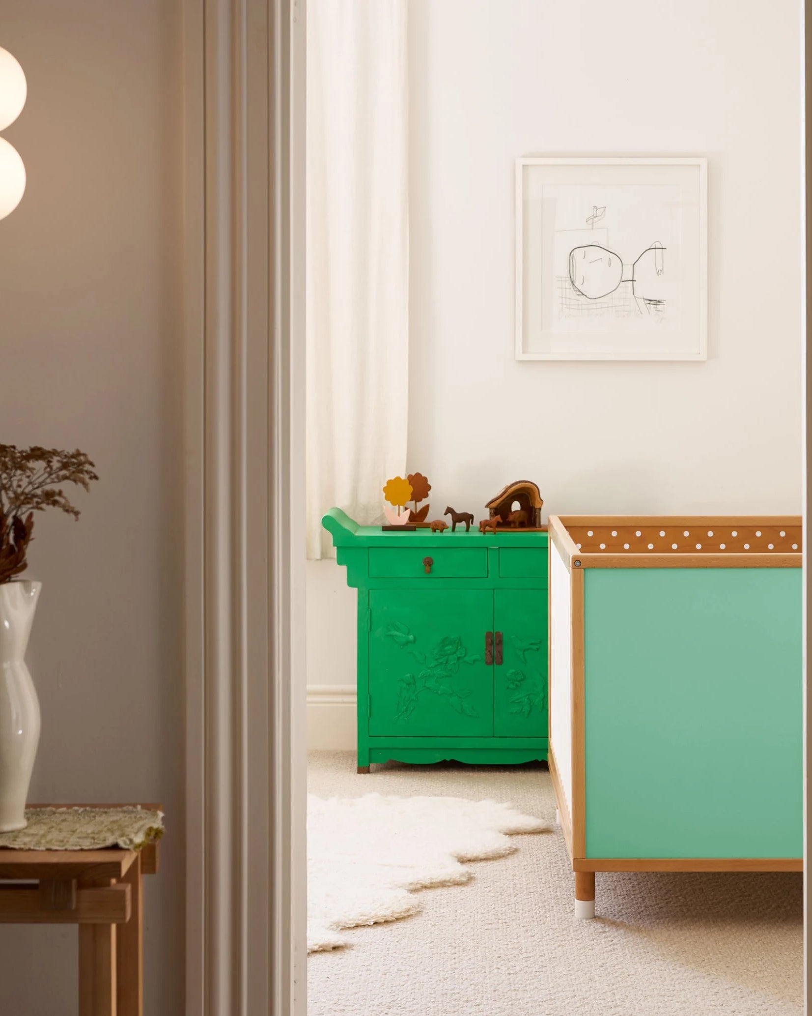 Teal and polkadot panels of the Bold Baby Cot shown in a styled nursery.