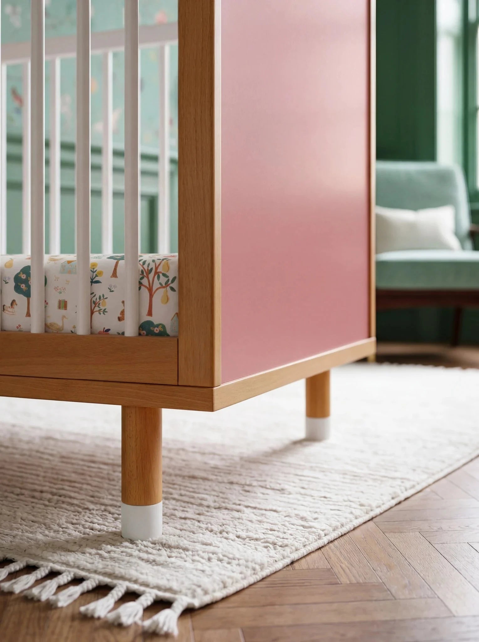 Pink panel and adjustable leg detail of the Pink and Green Bold Baby Cot