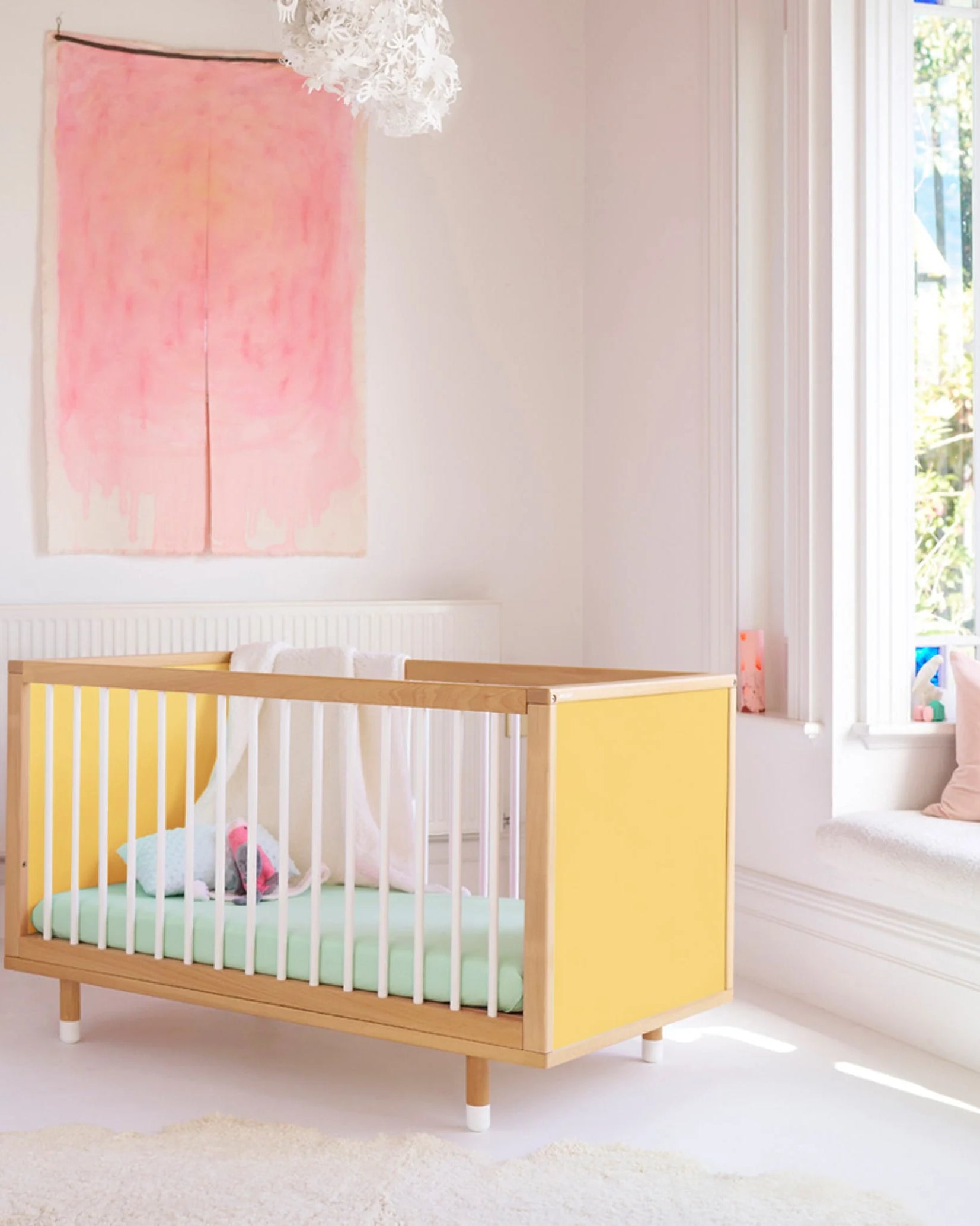 Yellow panels of the Bold Baby Cot shown from a side angle