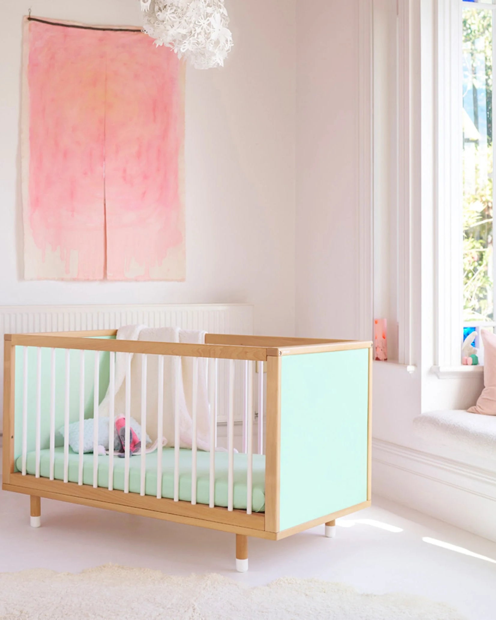 Green and Mint Bold Baby Cot styled in a nursery setting. Mint panels on display.