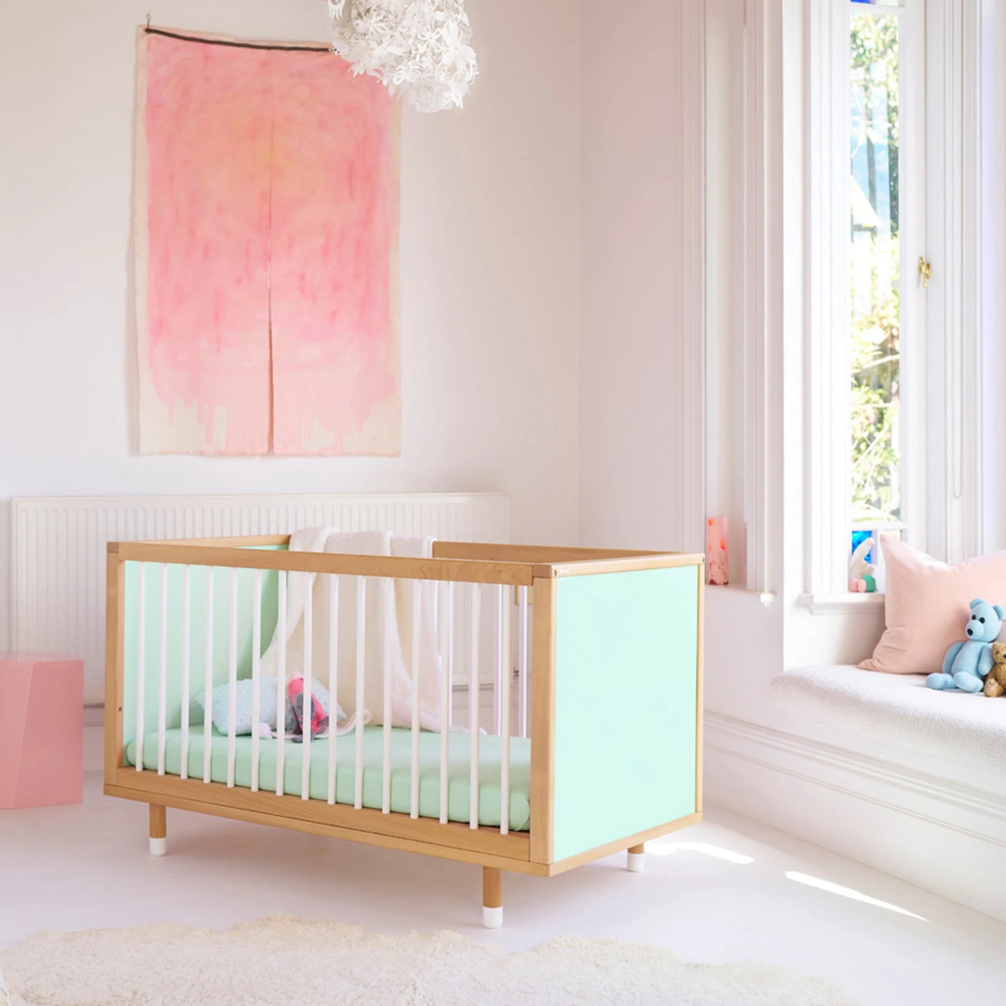 Green and Mint Bold Baby Cot styled in a nursery setting. Mint panels on display.