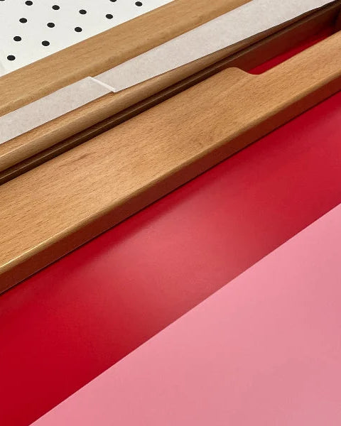 Pink, red and pegboard interchangeable panel boards of the Bold Baby Cot.