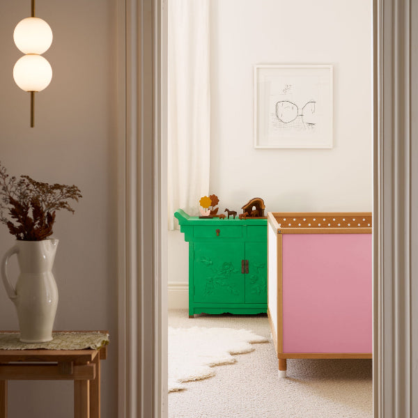 A pink cot in a room