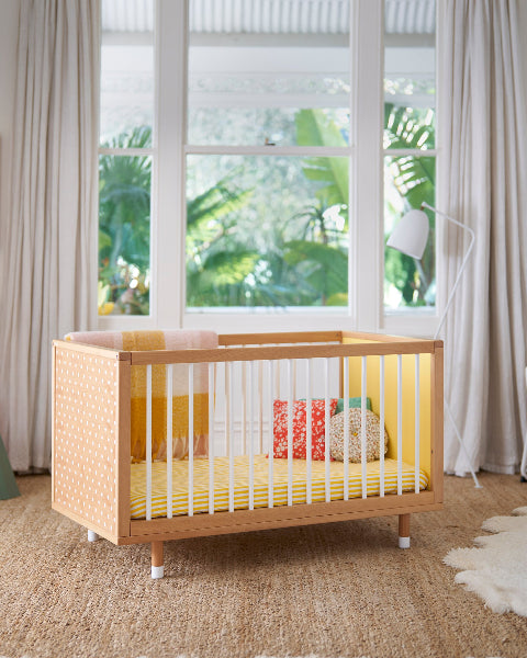 A yellow cot in a styled room