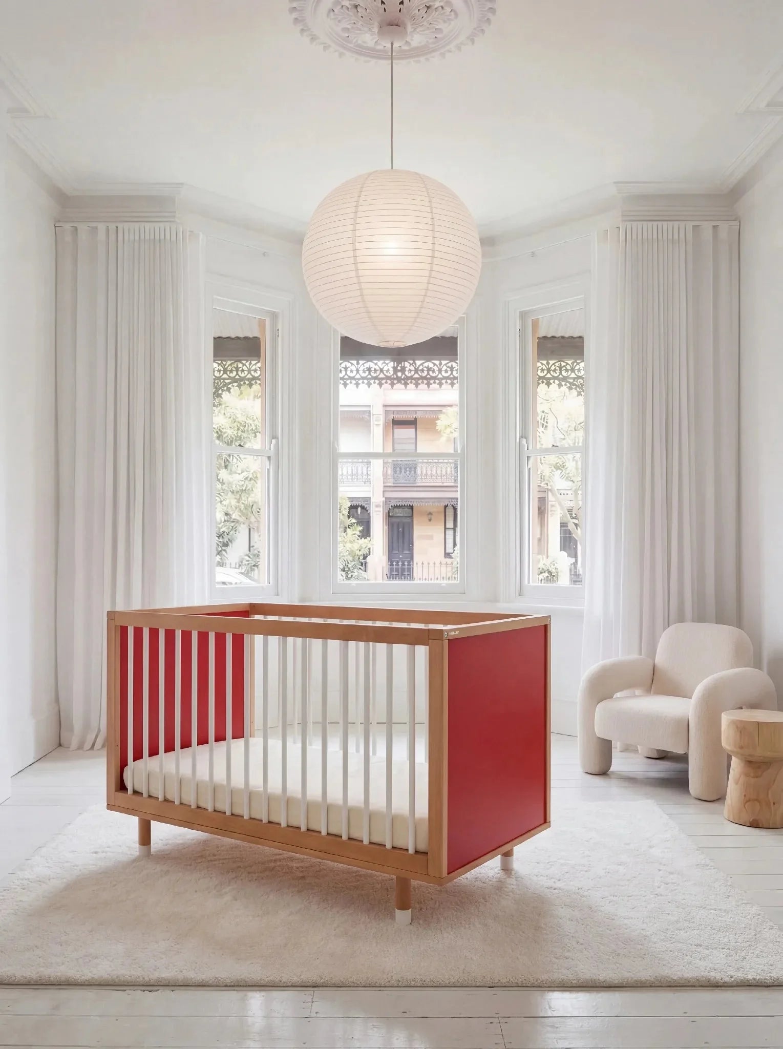 Bold Baby Cot in Pink and Red colourway, front three-quarter view showing the red panel