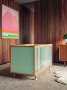 Bold Baby Cot in Green and Mint colourway, front three-quarter view showing the mint panel