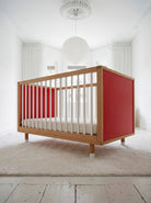Low-angle front view of the Pink and Red Bold Baby Cot