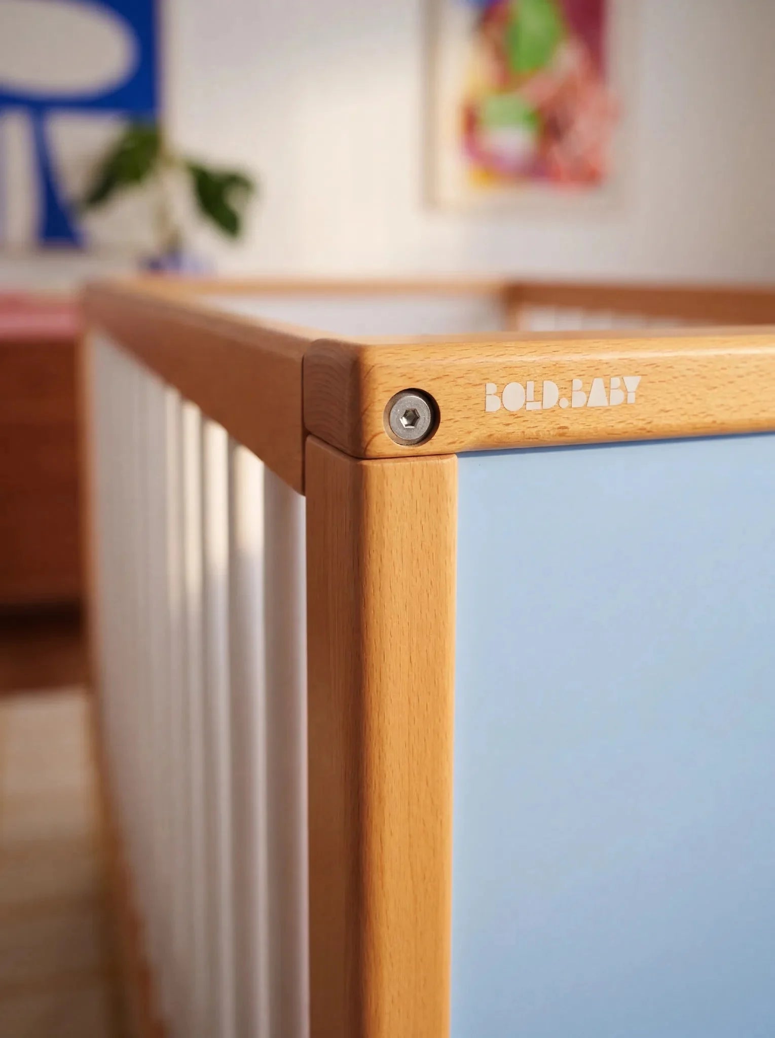 Close-up corner detail of the interchangeable panel on the Blue and Deep Blue Bold Baby Cot