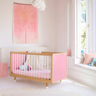 Pink and Red Bold Baby Cot styled in a nursery setting. Pink panels on display.