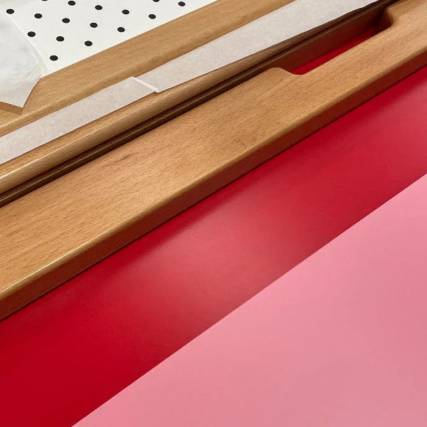 Pink, red and pegboard interchangeable panel boards of the Bold Baby Cot.