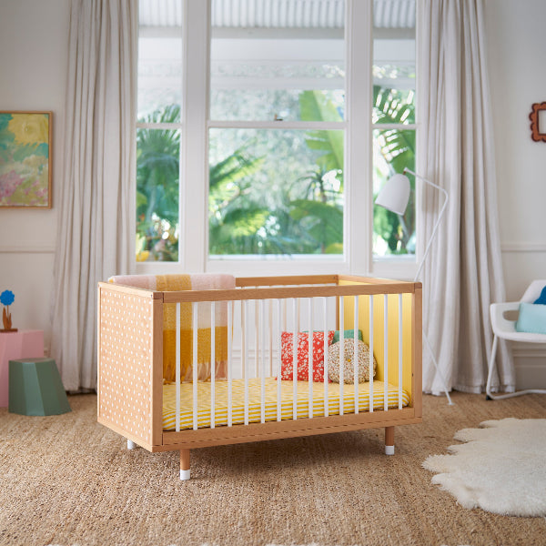 A yellow cot in a styled room