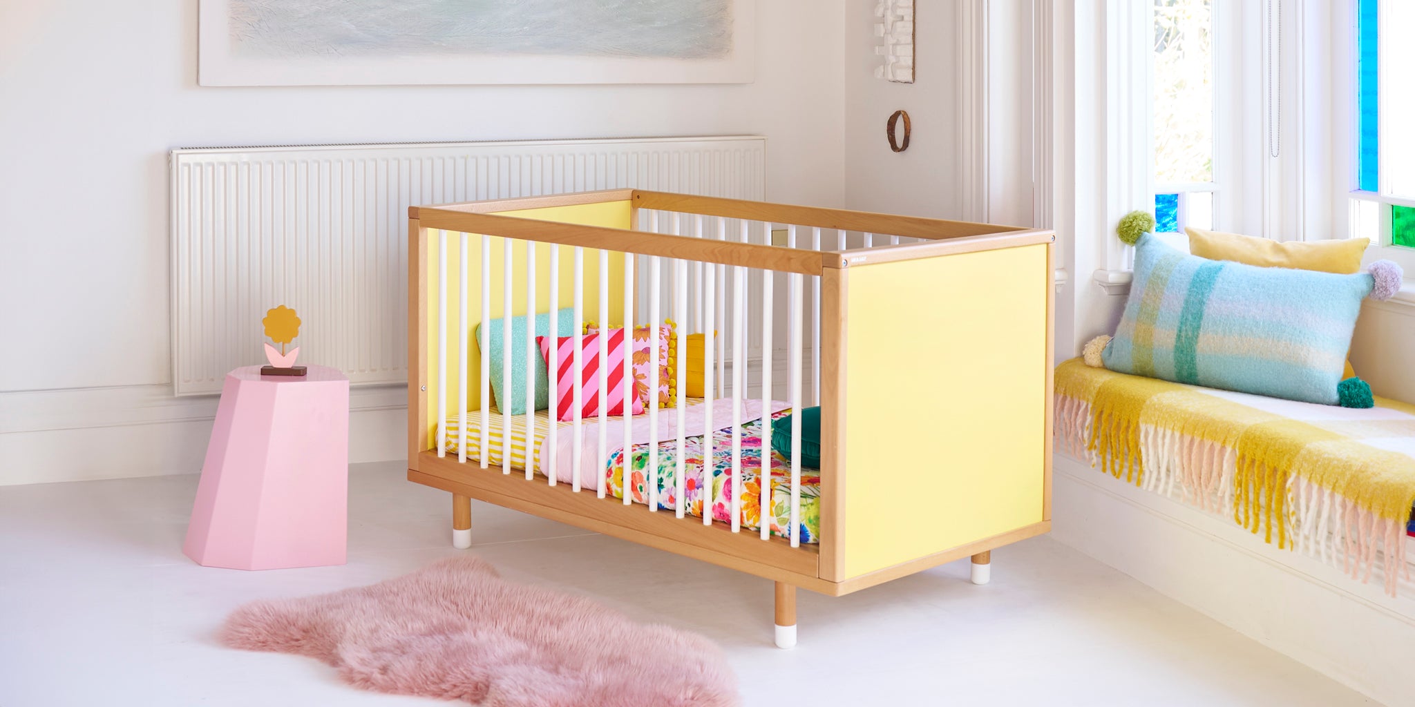 A customisable, designer yellow cot in a stylish white room
