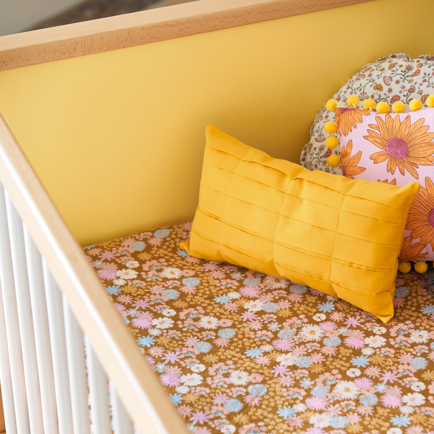 A yellow cushion on a cot sheet