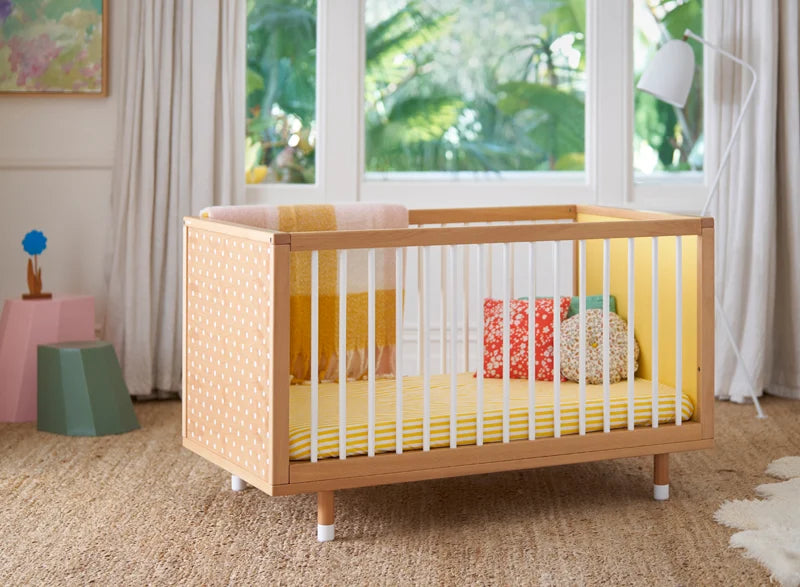A yellow Bold baby cot in a stylish nursery