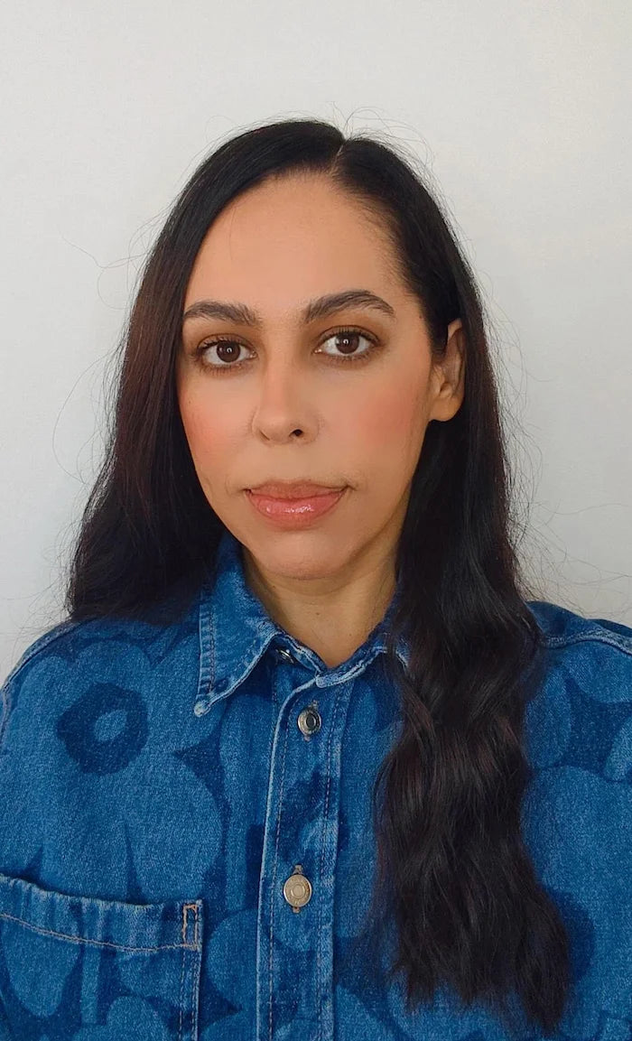 Woman wearing a blue floral shirt against a white background