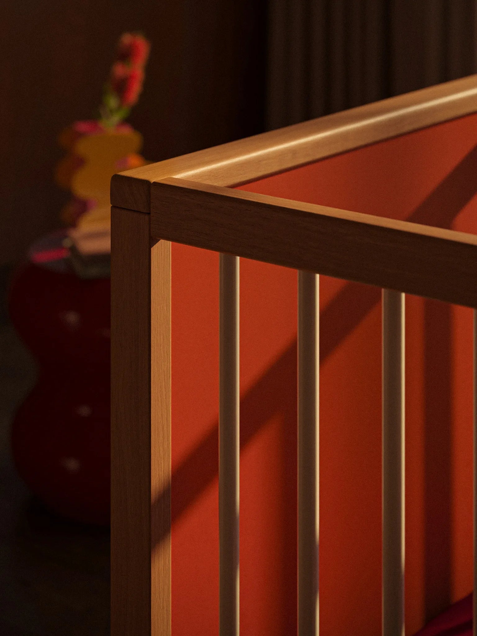 Top corner detail of the Bold Baby Art Series cot in warm light