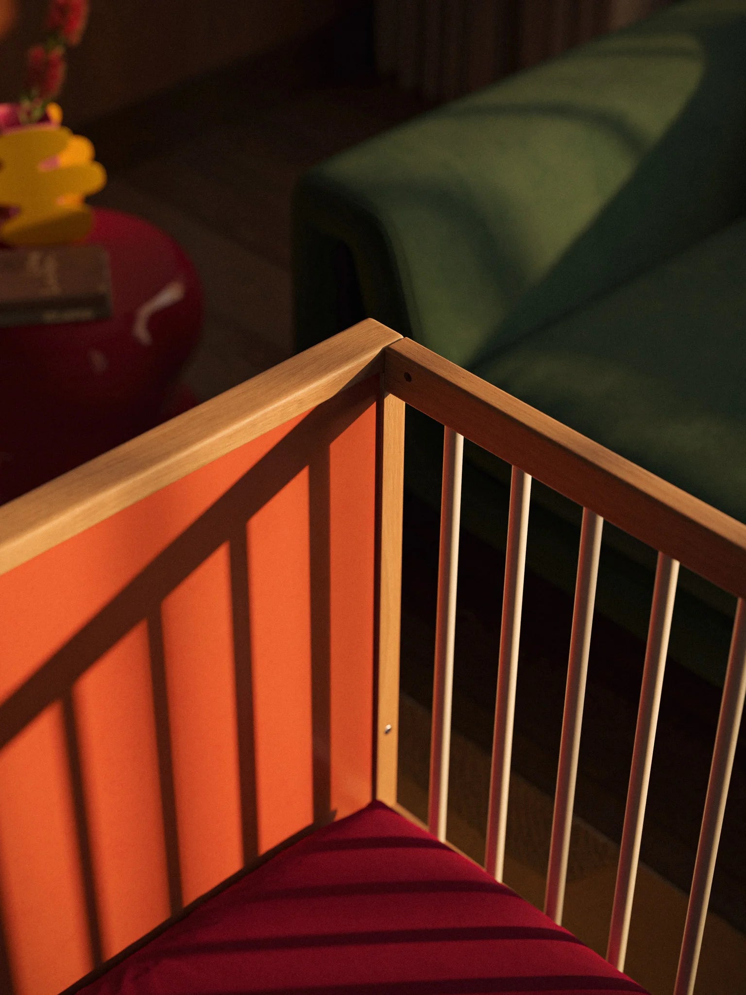 Close-up of the Bold Baby Art Series cot frame and maroon mattress
